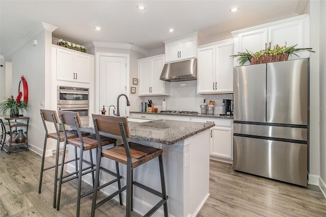 2342 Clemblue Rd, Clermont, FL 34715 - kitchen with appliances with stainless steel finishes, under cabinet range hood, a sink, ornamental molding, and light wood finished floors