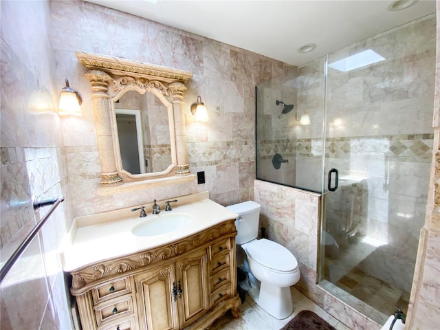 full bathroom featuring tile walls, toilet, vanity, and a shower stall