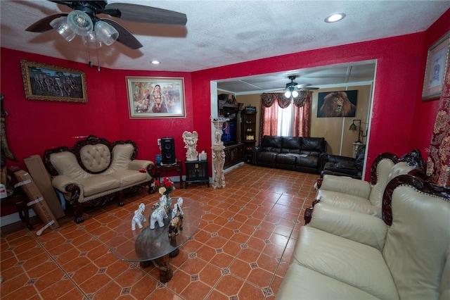 living room featuring ceiling fan, a textured ceiling, and recessed lighting
