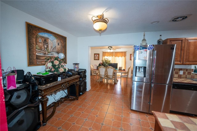 kitchen with appliances with stainless steel finishes, brown cabinetry, and a ceiling fan