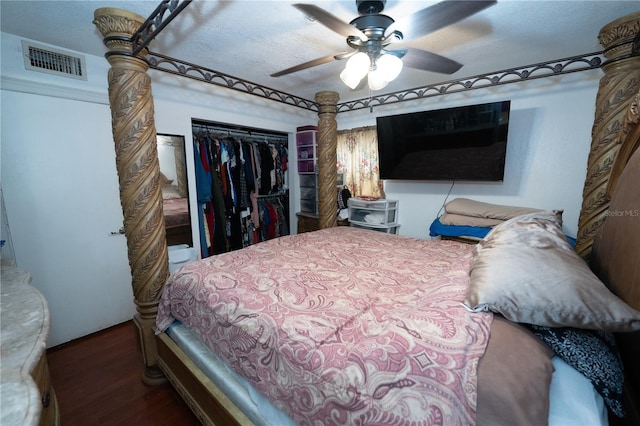 bedroom featuring a closet, wood finished floors, ceiling fan, and decorative columns