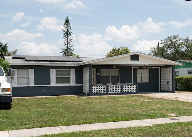 ranch-style home with ceiling fan, a front lawn, covered porch, and roof mounted solar panels