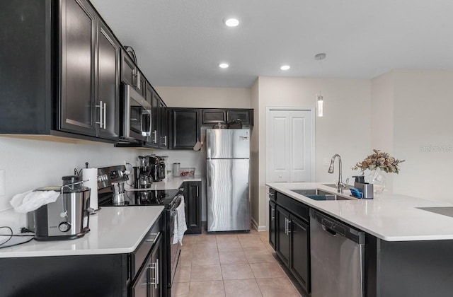 601 Watusi Way, Saint Cloud, FL 34772 - kitchen featuring stainless steel appliances, a sink, dark cabinetry, light countertops, and recessed lighting