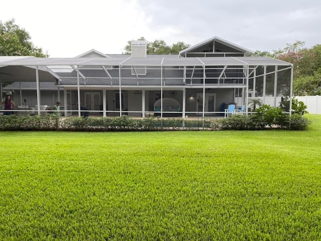 3009 Ridgevale Cir, Valrico, FL 33596 - rear view of house featuring a lawn, glass enclosure, and a chimney