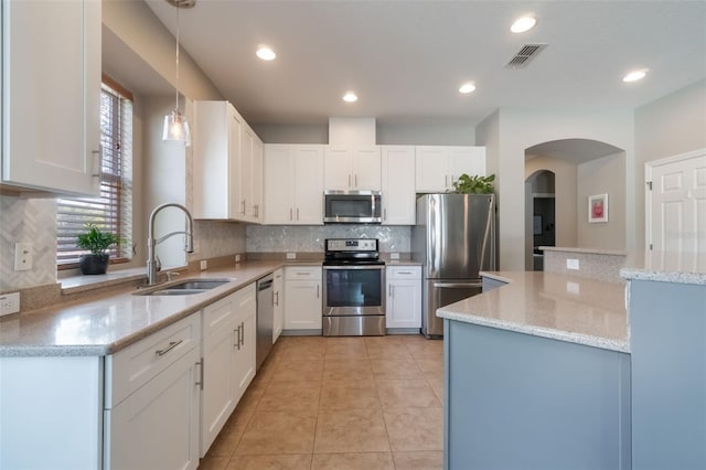 3223 Blazing Star Ln, Harmony, FL 34773 - kitchen featuring stainless steel appliances, a sink, arched walkways, backsplash, and recessed lighting