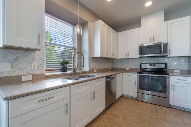 3223 Blazing Star Ln, Harmony, FL 34773 - kitchen with stainless steel appliances, a sink, white cabinets, backsplash, and recessed lighting