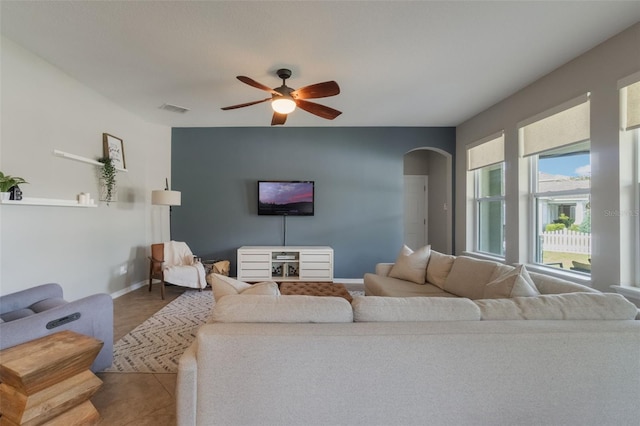 3223 Blazing Star Ln, Harmony, FL 34773 - living area featuring a ceiling fan, arched walkways, and baseboards