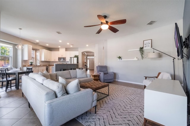 3223 Blazing Star Ln, Harmony, FL 34773 - living room featuring arched walkways, a ceiling fan, baseboards, light tile patterned floors, and recessed lighting