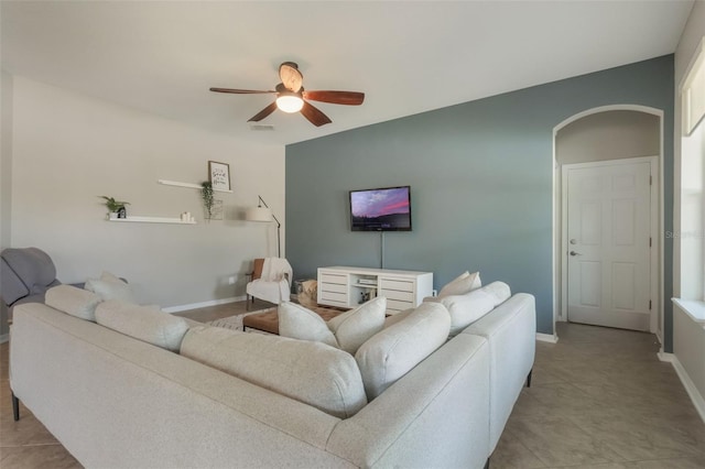 3223 Blazing Star Ln, Harmony, FL 34773 - living area featuring ceiling fan, arched walkways, baseboards, and light tile patterned flooring
