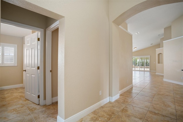 2830 Alton Dr, Kissimmee, FL 34741 - corridor with arched walkways, light tile patterned floors, lofted ceiling, and baseboards