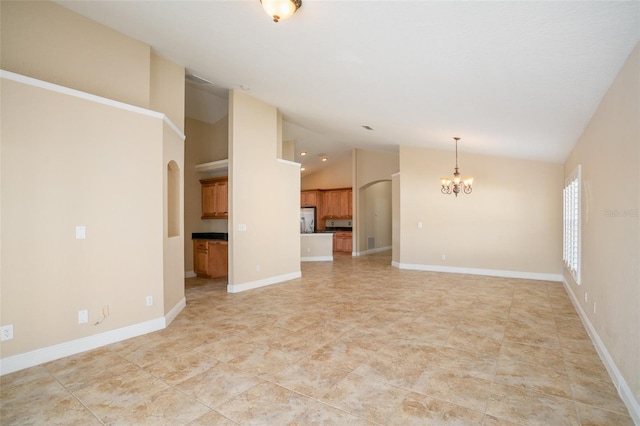 2830 Alton Dr, Kissimmee, FL 34741 - unfurnished living room with a chandelier, lofted ceiling, arched walkways, and baseboards