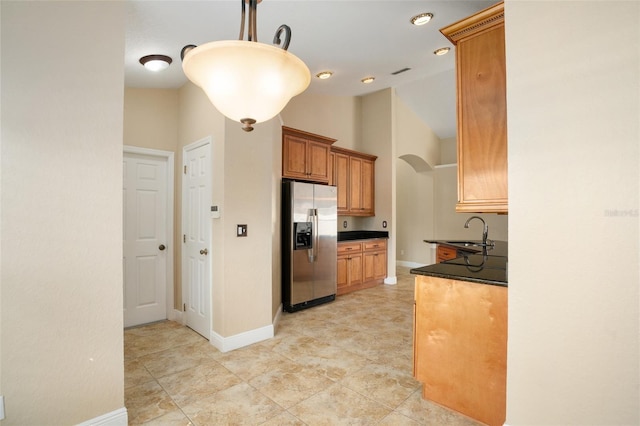 2830 Alton Dr, Kissimmee, FL 34741 - kitchen featuring stainless steel refrigerator with ice dispenser, dark countertops, a sink, baseboards, and high vaulted ceiling