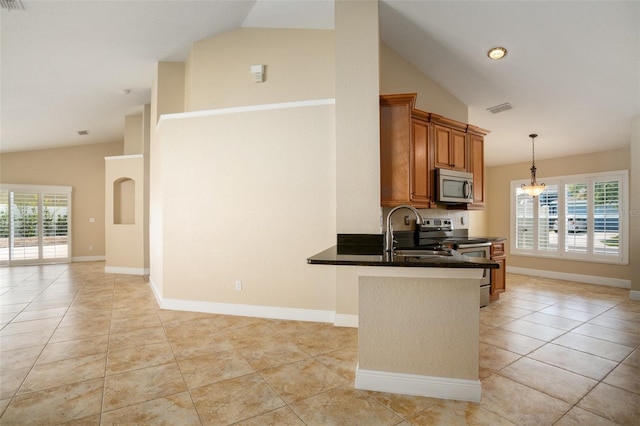 2830 Alton Dr, Kissimmee, FL 34741 - kitchen with stainless steel appliances, a sink, brown cabinets, dark countertops, and pendant lighting