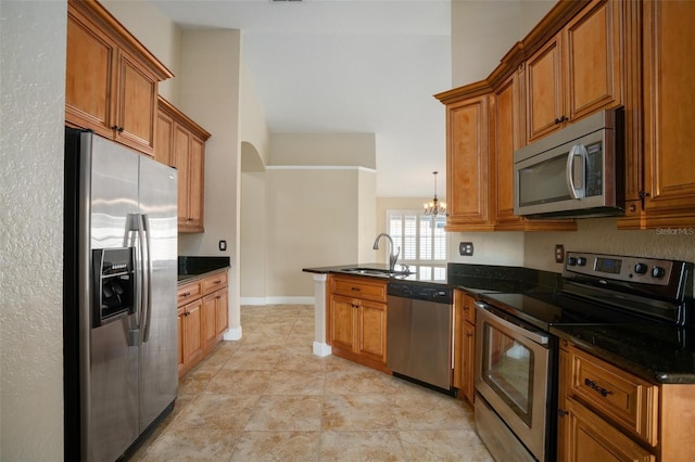 2830 Alton Dr, Kissimmee, FL 34741 - kitchen with stainless steel appliances, a sink, a peninsula, and brown cabinets