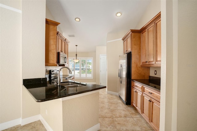 2830 Alton Dr, Kissimmee, FL 34741 - kitchen featuring a sink, appliances with stainless steel finishes, a peninsula, decorative light fixtures, and brown cabinets