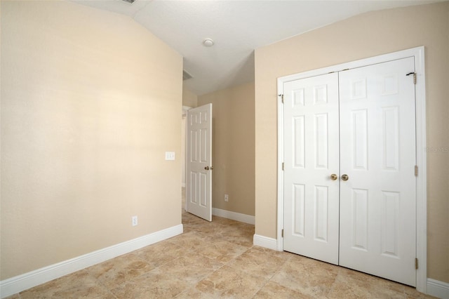 2830 Alton Dr, Kissimmee, FL 34741 - unfurnished bedroom featuring lofted ceiling, a closet, and baseboards