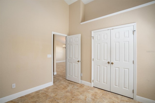 2830 Alton Dr, Kissimmee, FL 34741 - unfurnished bedroom featuring a closet, high vaulted ceiling, baseboards, a chandelier, and tile patterned flooring