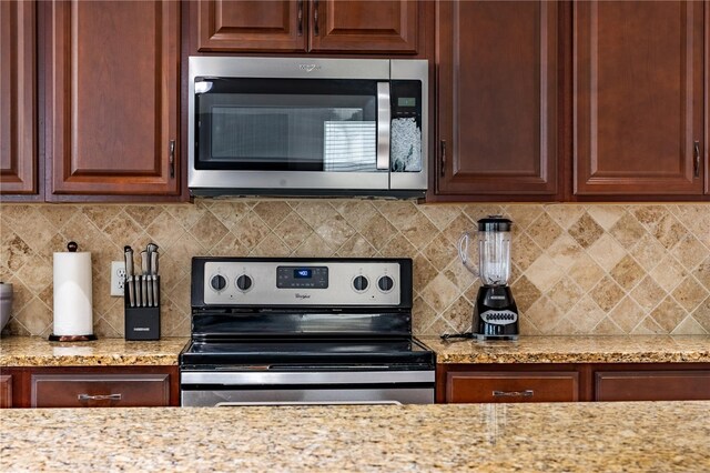 1836 Sandy Park Trl, Kissimmee, FL 34747 - kitchen with appliances with stainless steel finishes, backsplash, and light stone countertops