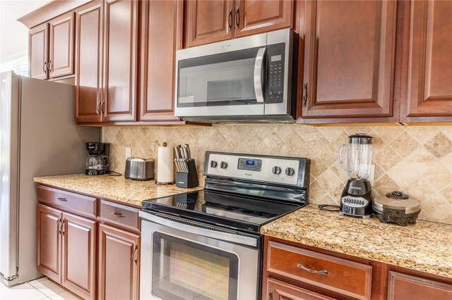 1836 Sandy Park Trl, Kissimmee, FL 34747 - kitchen featuring stainless steel appliances, light stone countertops, and decorative backsplash