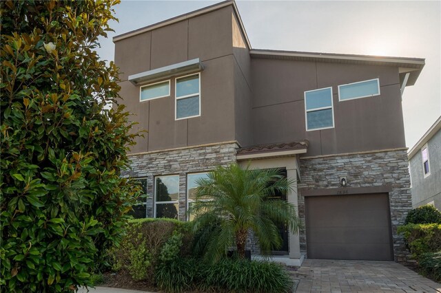 1836 Sandy Park Trl, Kissimmee, FL 34747 - view of front of house featuring stone siding, stucco siding, a garage, and driveway