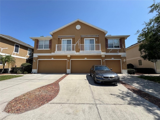 7544 Red Mill Cir, New Port Richey, FL 34653 - view of front facade featuring concrete driveway, an attached garage, stucco siding, and a balcony