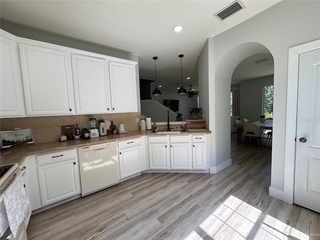 7544 Red Mill Cir, New Port Richey, FL 34653 - kitchen featuring white appliances, a sink, arched walkways, light wood-type flooring, and decorative backsplash