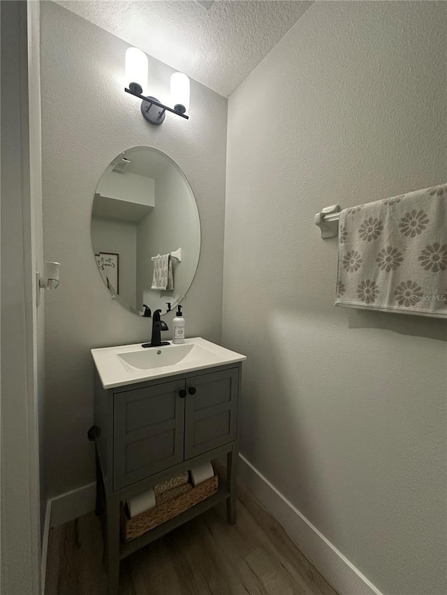 7544 Red Mill Cir, New Port Richey, FL 34653 - bathroom with a textured ceiling, wood finished floors, vanity, and baseboards
