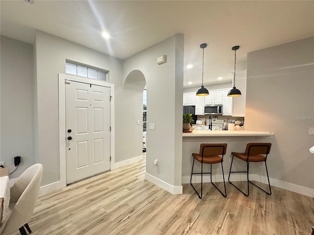 7544 Red Mill Cir, New Port Richey, FL 34653 - entrance foyer featuring light wood finished floors, arched walkways, recessed lighting, and baseboards