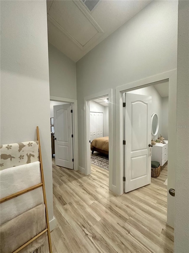 7544 Red Mill Cir, New Port Richey, FL 34653 - hall featuring attic access, light wood-style floors, and a high ceiling