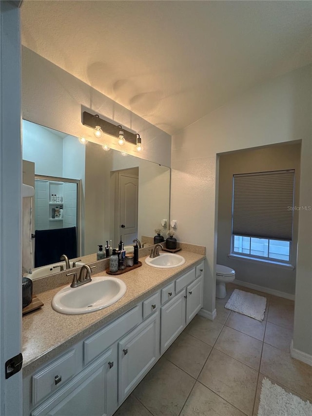 7544 Red Mill Cir, New Port Richey, FL 34653 - bathroom with double vanity, tile patterned floors, toilet, baseboards, and lofted ceiling