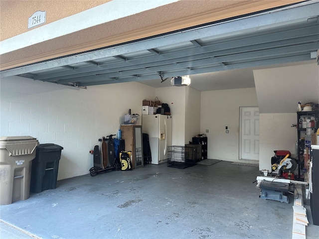 7544 Red Mill Cir, New Port Richey, FL 34653 - garage with white refrigerator with ice dispenser and a garage door opener