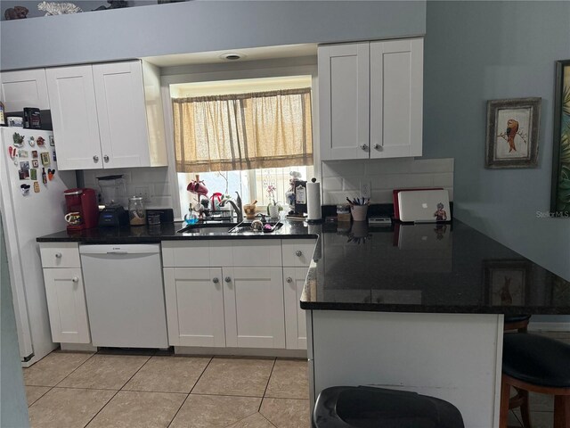4186 Buglers Rest Pl, Casselberry, FL 32707 - kitchen with white appliances, a sink, a peninsula, white cabinets, and light tile patterned floors