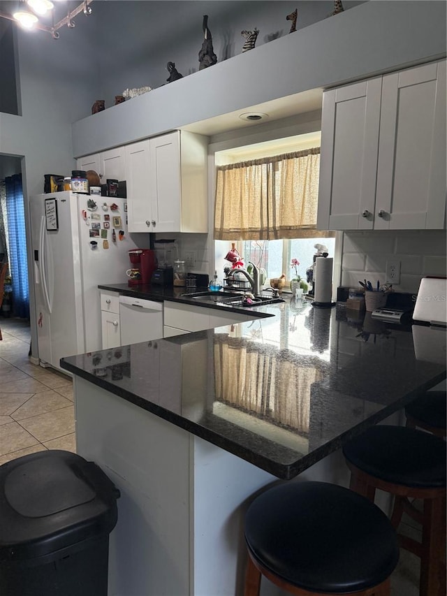 4186 Buglers Rest Pl, Casselberry, FL 32707 - kitchen with white appliances, a peninsula, white cabinetry, a sink, and a kitchen breakfast bar