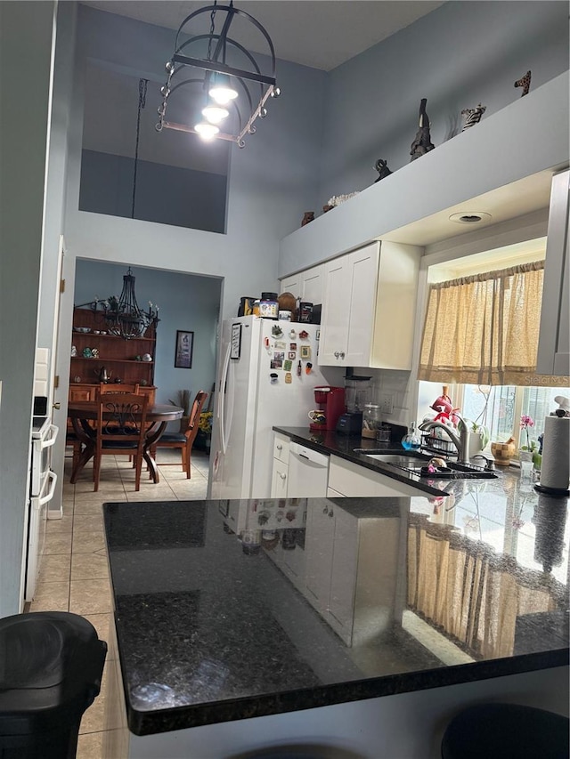 4186 Buglers Rest Pl, Casselberry, FL 32707 - kitchen featuring light tile patterned flooring, white appliances, white cabinets, a high ceiling, and dark stone countertops