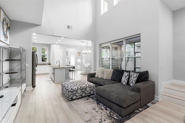 14126 Walcott Ave, Orlando, FL 32827 - living area featuring a chandelier, light wood-style floors, a high ceiling, recessed lighting, and baseboards
