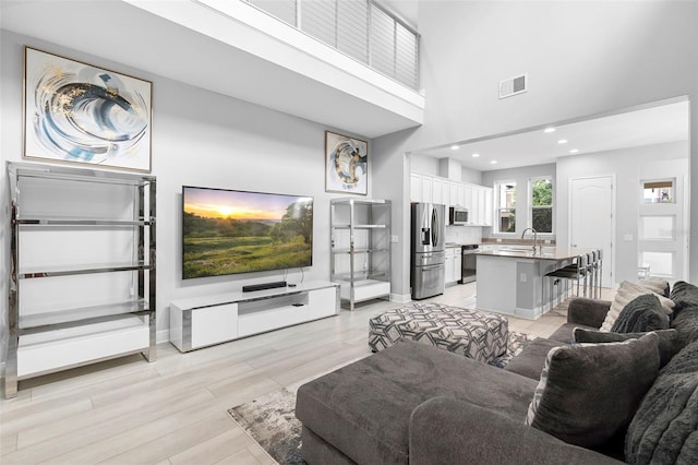 14126 Walcott Ave, Orlando, FL 32827 - living room featuring a towering ceiling, light wood-style floors, recessed lighting, and baseboards