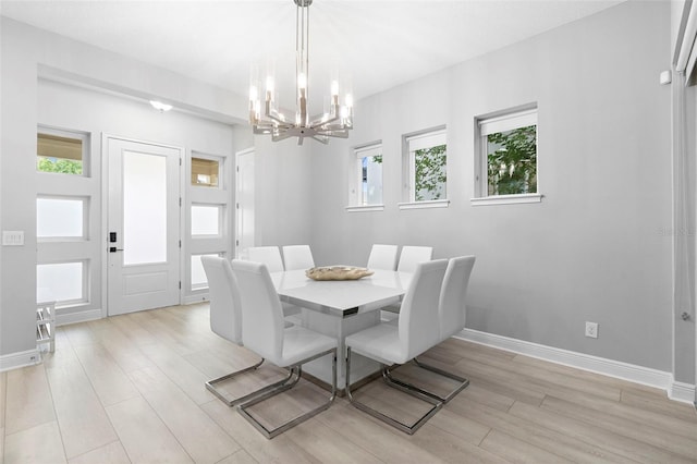 14126 Walcott Ave, Orlando, FL 32827 - dining room featuring a chandelier, light wood-style floors, and baseboards