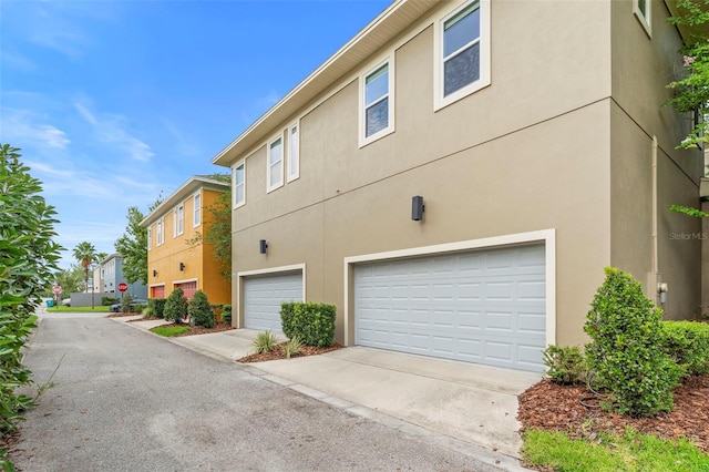 14126 Walcott Ave, Orlando, FL 32827 - view of property exterior featuring stucco siding, an attached garage, and concrete driveway