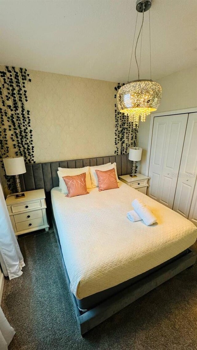 851 Drop Shot Dr, Davenport, FL 33896 - bedroom with dark colored carpet, a chandelier, and a closet