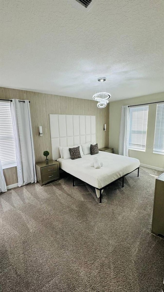 851 Drop Shot Dr, Davenport, FL 33896 - bedroom featuring a chandelier, carpet floors, a textured ceiling, and baseboards