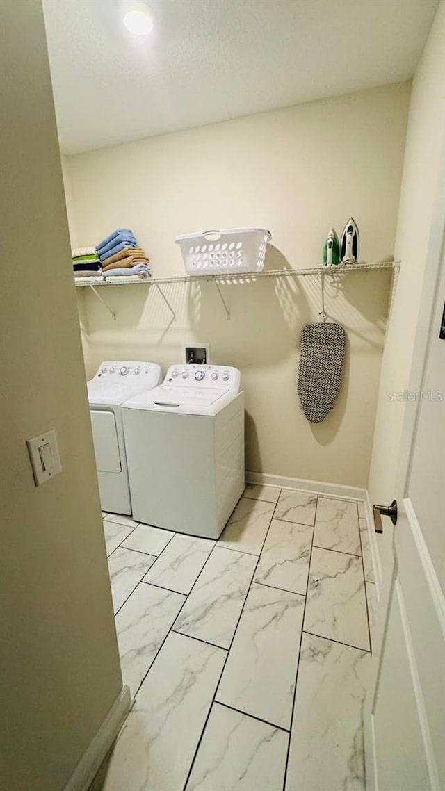 851 Drop Shot Dr, Davenport, FL 33896 - washroom featuring independent washer and dryer, light marble finish flooring, and baseboards