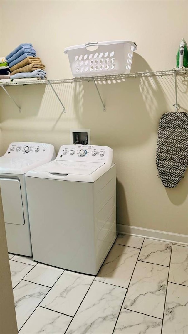 851 Drop Shot Dr, Davenport, FL 33896 - washroom with washer and clothes dryer, light marble finish floors, and baseboards