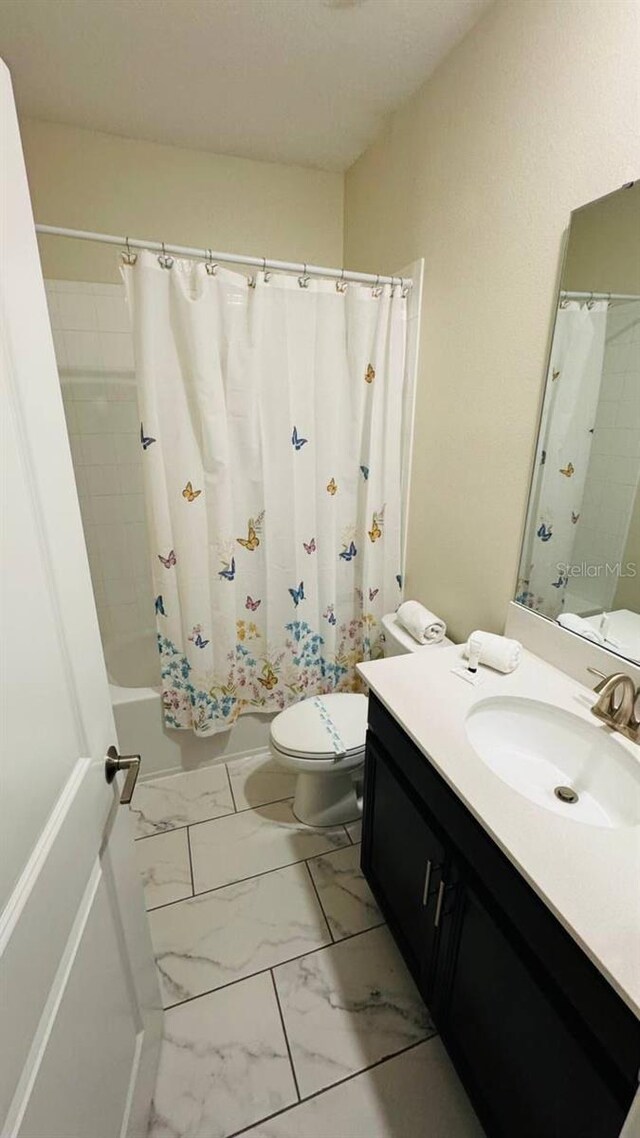 851 Drop Shot Dr, Davenport, FL 33896 - bathroom featuring toilet, vanity, shower / bath combo with shower curtain, and marble look tile flooring