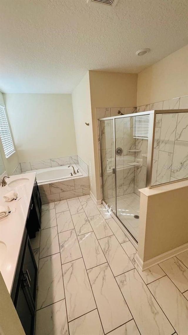 851 Drop Shot Dr, Davenport, FL 33896 - bathroom with marble finish floors, a bath, a shower stall, double vanity, and a textured ceiling
