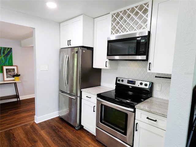 420 61st Ave S, Saint Petersburg, FL 33705 - kitchen with stainless steel appliances, decorative backsplash, baseboards, dark wood finished floors, and white cabinets