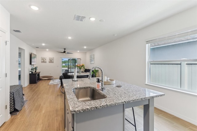 4122 Sagefield Dr, Saint Cloud, FL 34773 - kitchen with a sink, light wood-style floors, a kitchen island with sink, a ceiling fan, and recessed lighting