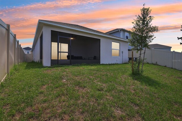 4122 Sagefield Dr, Saint Cloud, FL 34773 - back of property at dusk with a sunroom and stucco siding