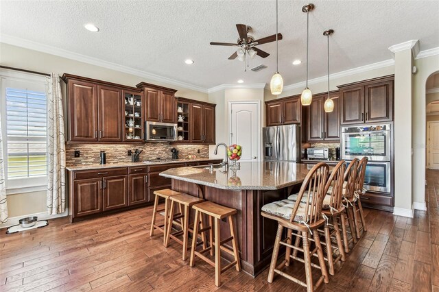 4133 Foxhound Dr, Clermont, FL 34711 - kitchen featuring stainless steel appliances, dark wood-style floors, a ceiling fan, a textured ceiling, and dark brown cabinetry