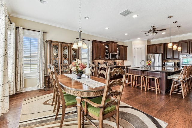 4133 Foxhound Dr, Clermont, FL 34711 - dining room with plenty of natural light, dark wood finished floors, ceiling fan, recessed lighting, and ornamental molding