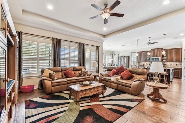 4133 Foxhound Dr, Clermont, FL 34711 - living area featuring a ceiling fan, light wood-style floors, a tray ceiling, and recessed lighting